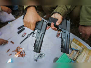 Samba: Security personnel display pistols, bullets and other objects recovered f...