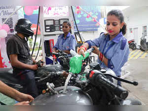 Employees attend customers at the first ever petrol pump in Jammu dedicat...