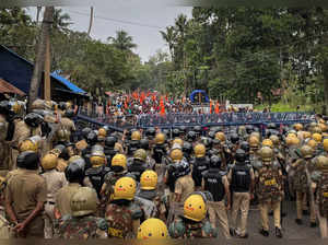 Police officers stand guard near the barricades during a protest rally by the supporters of the proposed Vizhinjam port project