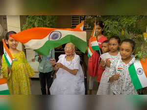 Gandhinagar: Prime Minister Narendra Modi’s mother Heeraben Modi holds the natio...