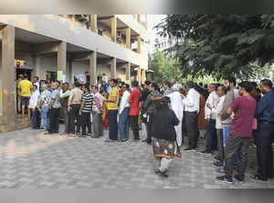 Vadodara: Voters wait in queues to cast their votes at a polling booth during th...