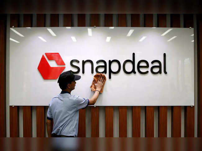FILE PHOTO: An employee cleans a Snapdeal logo at its headquarters in Gurugram