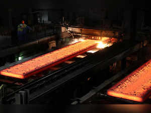 FILE PHOTO: Red-hot steel plates pass through a press at the Tata steel plant in Ijmuiden