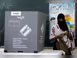 A woman leaves a polling booth after casting her vote, in Ahmedabad