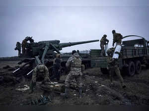 Ukrainian soldiers prepare to fire a Pion artillery system at Russian positions ...