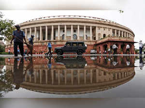 Indian parliament building is reflected in a puddle after the rain in New Delhi