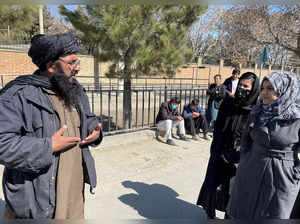 FILE PHOTO: A member of Taliban speaks with female students outside the Kabul Education University in Kabul