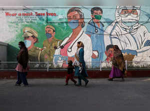 FILE PHOTO: Women walk past a mural amidst the spread of the coronavirus disease (COVID-19) in New Delhi