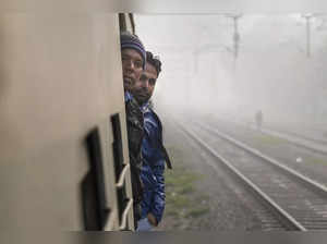 New Delhi: Commuters aboard a train amid dense fog on a cold winter morning, in ...