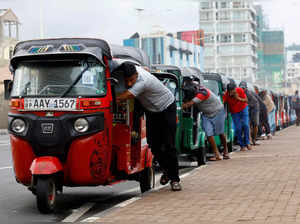 FILE PHOTO: Drivers push auto rickshaws in a line to buy petrol from a fuel station, amid Sri Lanka's economic crisis, in Colombo