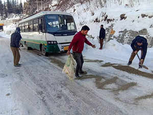 Manali: Himachal Road Transport Corporation (HRTC) workers clear snow from a hig...