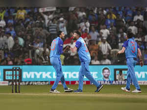 Pune: Indian bowler Axar Patel celebrates with team captain Hardik Pandya after ...