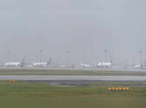 Chennai: Aeroplanes stand parked on a runway amid low visibility as operation of...