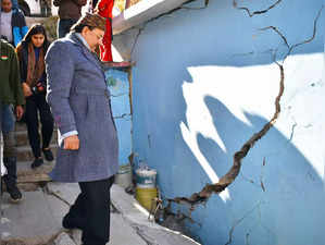 Joshimath: MoS for Defence Ajay Bhatt inspects massive cracks in a house developed due to land subsidence in Joshimath on Tuesday, Jan. 10, 2023. (Photo: Rameshwar Gaur/IANS)