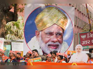 New Delhi: BJP supporters wait for Prime Minister Narendra Modi during his roads...