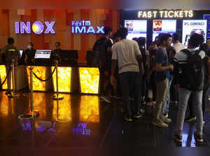 FILE PHOTO: People wait to buy tickets outside an INOX movie theatre in Mumbai