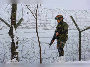Poonch: An Indian Army soldier patrols near a fence at Line of Control (LoC) ahe...