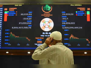 A broker talks on a phone as he watches latest share prices at the Pakistan Stock Exchange in Karachi on January 27, 2023. The IMF will send a team to Pakistan next week to discuss reviving a desperately needed bailout programme, with a foreign exchange crisis bringing imports almost to a standstill.   (Photo by Asif HASSAN / AFP)
