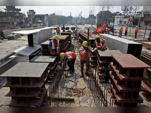 Labourers work at the site of an under construction flyover in Kolkata