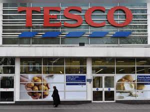 FILE PHOTO: Woman walks past a Tesco supermarket in central London