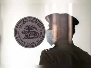 A security guard stands next to the logo of the Reserve Bank of India (RBI) inside its headquarters in Mumbai