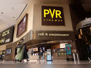 Women walk outside a PVR movie theatre in Mumbai
