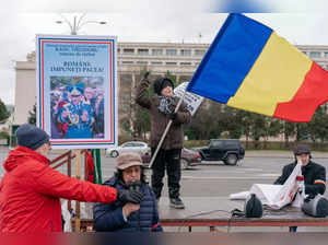 A boy holds a Romanian flag as he attends a rally against the involvement of Romania in the war between Russia and Ukraine, on January 24, 2023, in Bucharest, Romania. (Photo by Andrei Pungovschi / AFP)