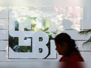 A woman walks past the logo of the Securities and Exchange Board of India (SEBI), at its headquarters in Mumbai