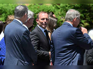 Australia's former premier Tony Abbott (C) attends the funeral procession of late Australian Catholic Cardinal George Pell outside St. Mary's Cathedral in Sydney on February 2, 2023.  Protestors confronted mourners with chants of "shame" outside the funeral of controversial top Vatican cardinal George Pell in Sydney on February 2. (Photo by Saeed KHAN / AFP)