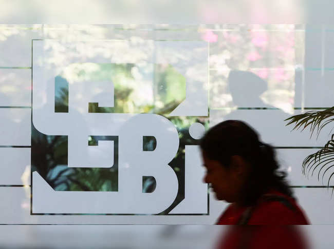 A woman walks past the logo of the Securities and Exchange Board of India (SEBI), at its headquarters in Mumbai