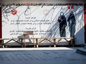A banner ordering women to cover themselves with a Hijab is pictured at a private university after the universities were reopened in Kabul on March 6, 2023. Male students trickled back to their classes Monday after Afghan universities reopened following a winter break but women remain barred by Taliban authorities. (Photo by Wakil KOHSAR / AFP)