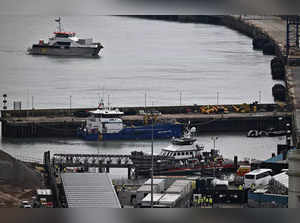 Migrants are escorted ashore from the UK Border Force vessel 'BF Ranger' in Dover, southeast England, on March 6, 2023, after having been picked up at sea while attempting to cross the English Channel. Britain's Conservative government is expected to present on Tuesday a new bill providing for the detention and swift deportation of asylum seekers who illegally enter the country via small boats, according to media reports. (Photo by Ben Stansall / AFP)