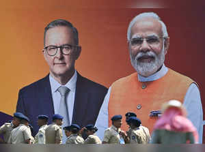 Police personnel stand next to a poster with the pictures of Australia's Prime Minister Anthony Albanese (L) and Indian Prime Minister Narendra Modi at the Narendra Modi stadium in Ahmedabad on March 7, 2023. (Photo by Punit PARANJPE / AFP)