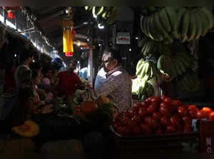 A fruit vendor tends to customers at a fruit and vegetable wholesale market in Mumbai