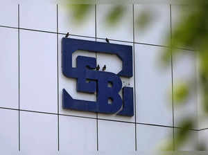 Birds rest on the logo of SEBI installed on the facade of its head office building in Mumbai