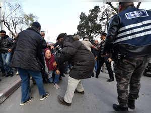 People help a fallen woman as Police officers try to disperse demonstrators in Tunis on March 5, 2023, rallying in defiance of a protest ban, to demand the release of prominent figures opposed to the president who were arrested in recent weeks. More than 20 political figures have been arrested in the North African country in recent weeks, including members the main opposition coalition, the National Salvation Front (NSF) and its main component, the Islamist-leaning Ennahdha party. (Photo by FETHI BELAID / AFP)