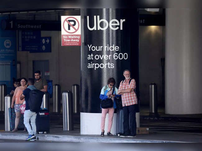 FILE PHOTO: Passengers wait for Uber ride-share cars at LAX