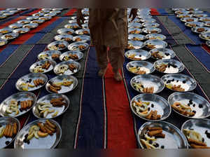 Man walks to inspect food plates before Iftar (breaking fast) during the fasting month of Ramadan, in Karachi