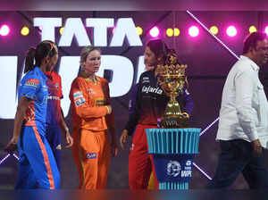 Mumbai Indians' captain Harmanpreet Kaur (L), Royal Challengers Bangalore captain Smriti Mandhana (2R) and Gujarat Giants' captain Beth Mooney (2L) gesture beside the trophy during the opening ceremony of 2023 Women's Premier League (WPL) at the DY Patil Stadium in Navi Mumbai on March 4, 2023.  - ----IMAGE RESTRICTED TO EDITORIAL USE - STRICTLY NO COMMERCIAL USE-----  (Photo by INDRANIL MUKHERJEE / AFP) / ----IMAGE RESTRICTED TO EDITORIAL USE - STRICTLY NO COMMERCIAL USE-----