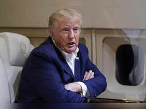 Former President Donald Trump speaks with reporters while in flight on his plane...