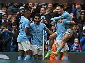 Manchester City's English midfielder Jack Grealish (R) celebrates with teammates after scoring their fourth goal during the English Premier League football match between Manchester City and Liverpool at the Etihad Stadium in Manchester, north west England, on April 1, 2023. RESTRICTED TO EDITORIAL USE. No use with unauthorized audio, video, data, fixture lists, club/league logos or 'live' services. Online in-match use limited to 120 images. An additional 40 images may be used in extra time. No video emulation. Social media in-match use limited to 120 images. An additional 40 images may be used in extra time. No use in betting