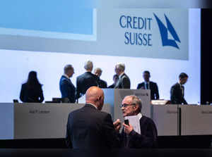 Shareholders chat in front of members of the board (behind) at the end of the last annual general meeting of Credit Suisse bank, in Zurich, on April 4, 2023, following the takeover by UBS of Credit Suisse hastily arranged by the Swiss government on March 19 to prevent a financial meltdown.  (Photo by Fabrice COFFRINI / AFP)