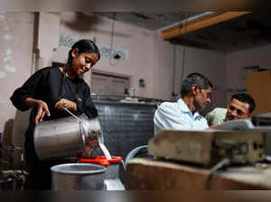 A girl pours milk into a container at a milk collection centre on the outskirts of Jaipur