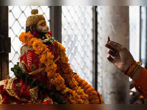 In this picture taken on September 13, 2022, a Hindu devotee performs a ritual to a garlanded Hindu god Hanuman at the Pracheen Hanuman temple in New Delhi. Religion plays a significant role in the lives of Indians and flowers have an equally pivotal role in the religious practices in the country. From Hindus to Muslims, the two largest religions in India, flowers and faith remain completely intertwined. India produces roughly 2,200 thousand tonnes of loose flowers, according to the federal horticulture department, nearly 70 percent of them are used in religious practices. The floriculture business was pegged at more