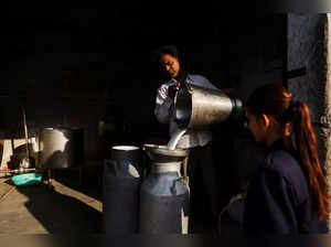A man pours milk into a container at a milk collection centre on the outskirts of Jaipur
