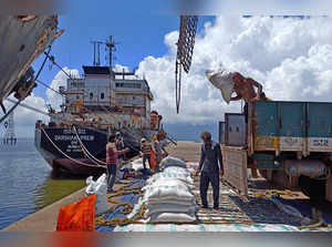 Labourers unload rice bags from a supply truck at India's main rice port at Kakinada Anchorage