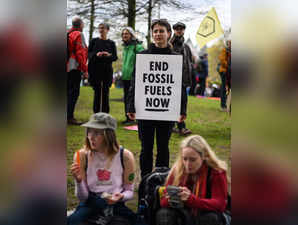 A protester holds a placard reading "End Fossil Fuels now" during a demonstration march to end fossil fuels in central London, on April 24, 2023, during Extinction Rebellion's The Big One event. Environmental group Extinction Rebellion (XR) organised four days of action in London  ushering in a far less disruptive and more inclusive method than the mass lockdowns that have been its trademark. (Photo by Daniel LEAL / AFP)