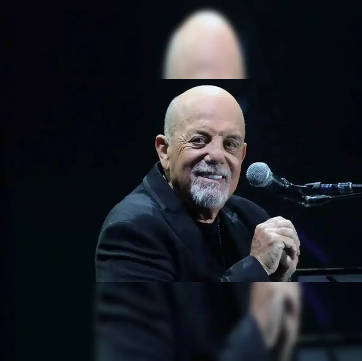 Billy Joel's iconic presence is captured during a poignant stage performance.