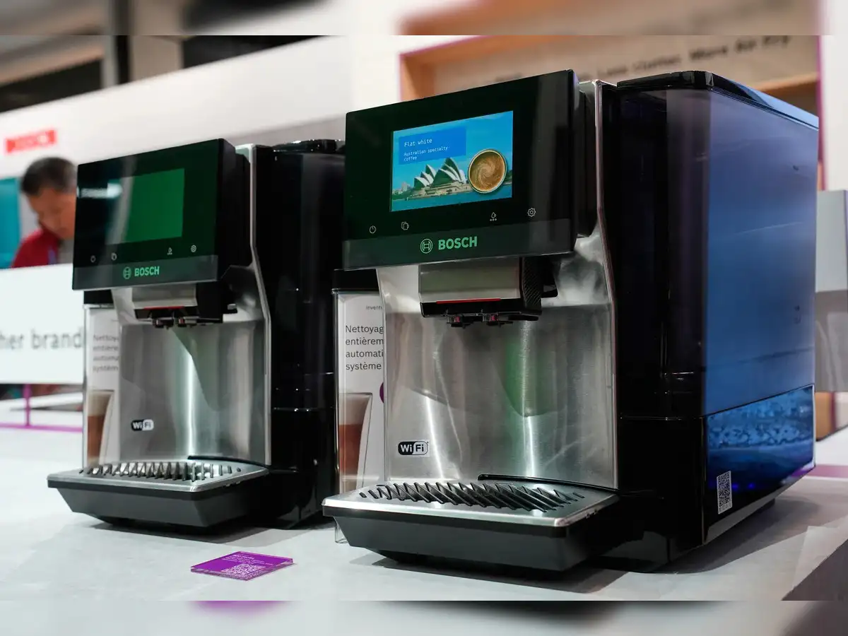 A conceptual image featuring a smart espresso machine, a futuristic perfume bottle, and a tennis robot, all representing AI at CES 2026.