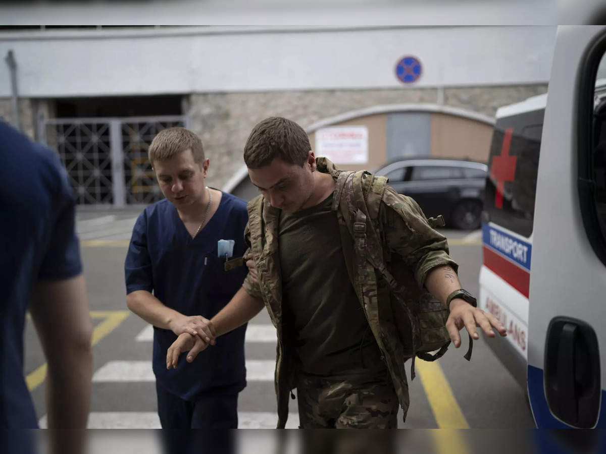 A shell-shocked Ukrainian soldier in a trench is getting taken